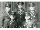 Fotografia grupowa 5 policjantów: Piotr Zapłata siedzi z prawej w mundurze przod. PWŚ.