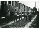 Fotografia grupowa na tle wagonów kolejowych: Jan Wieczorek drugi z prawej.