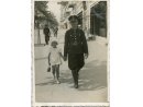 Fotografia: Przodownik PP Ignacy Wolny w mundurze na ulicy z dzieckiem. 
